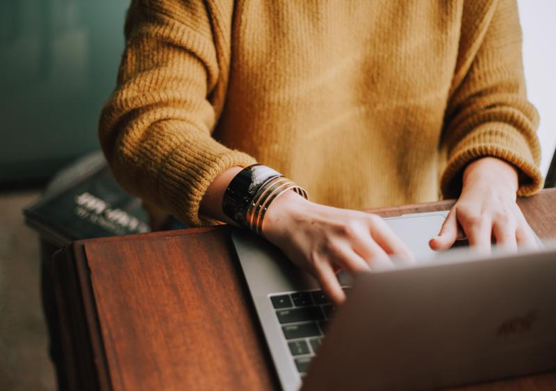 Person sitting at laptop to attend a webinar